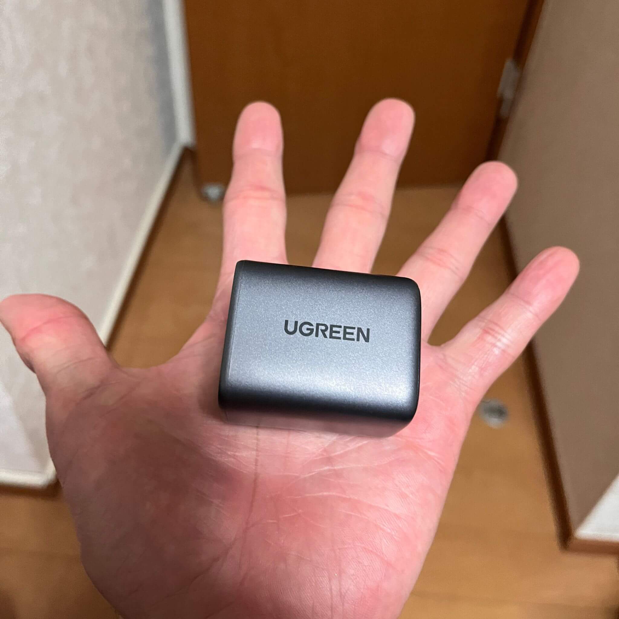 UGREENの充電器が手に乗っている。