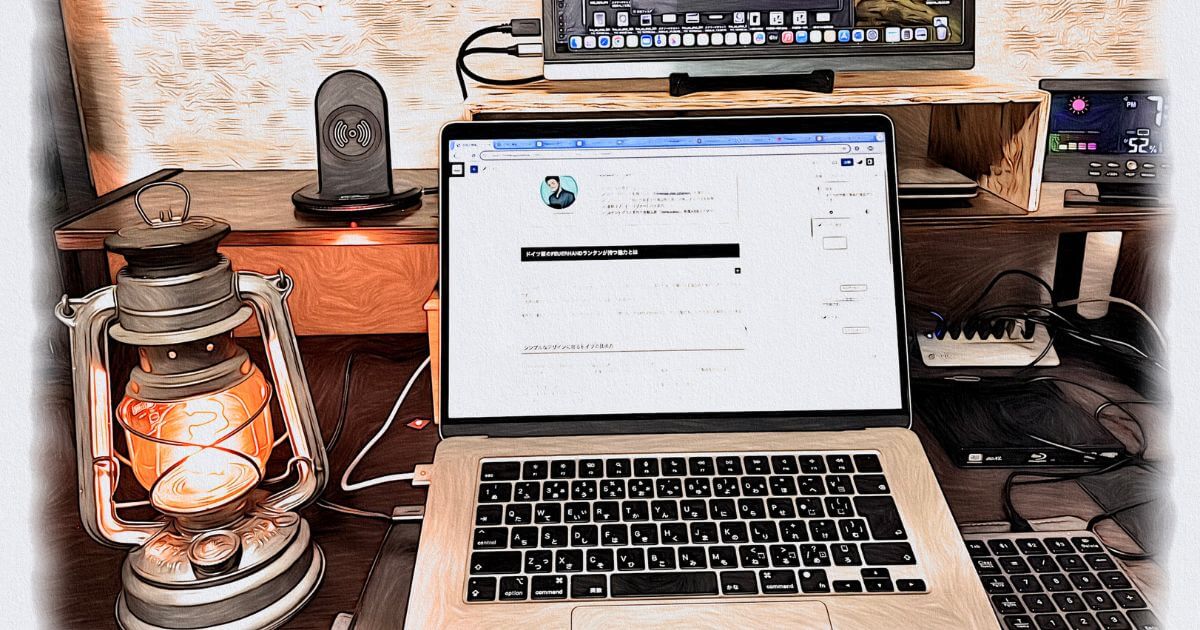 点灯したランタンの横の机の上にあるラップトップパソコン