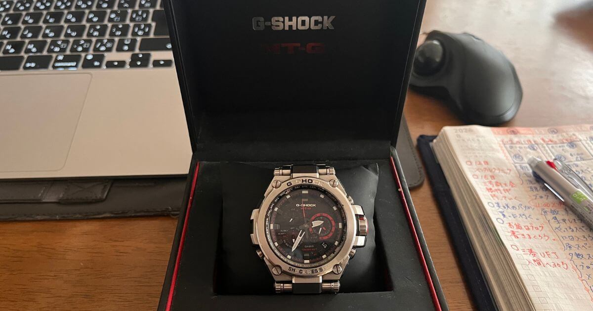 G-SHOCK MT-Gの腕時計が、開いた箱の中で、赤いアクセントの入った黒いクッションの上に置かれています。